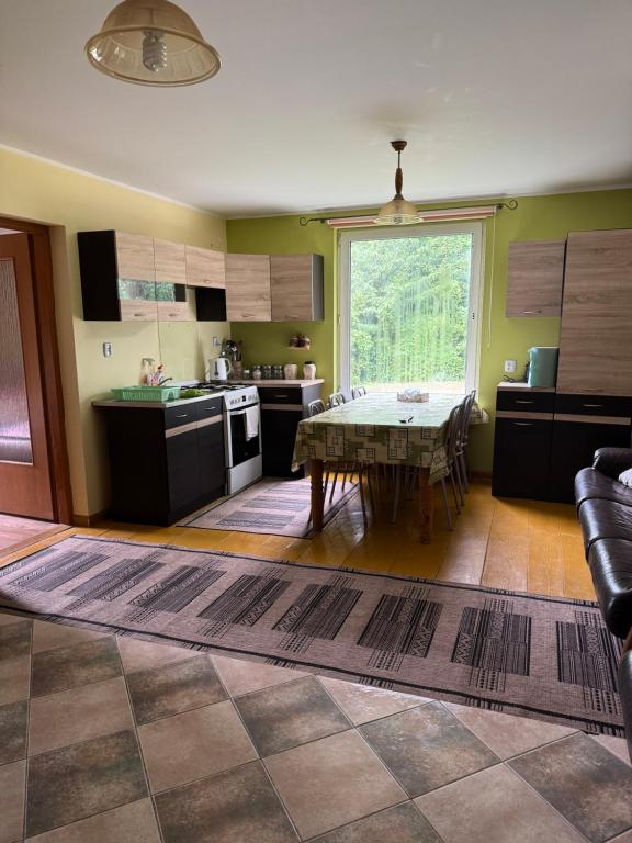 a kitchen with a table and a large window at Domek Krysi in Smorczewo