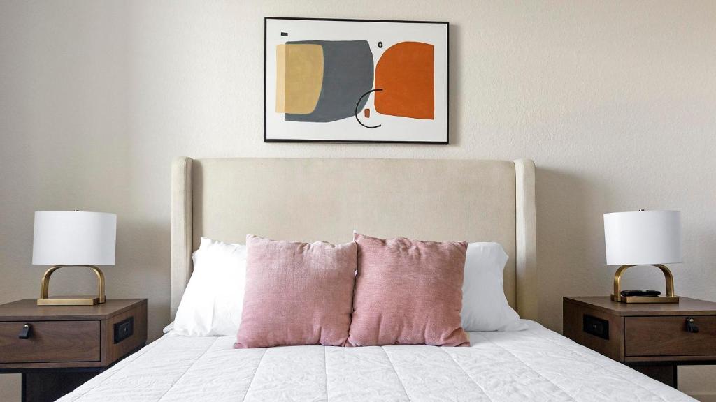 a bedroom with a bed with two nightstands and two lamps at Landing at Champions Walk - Longboat Key in Longboat Key