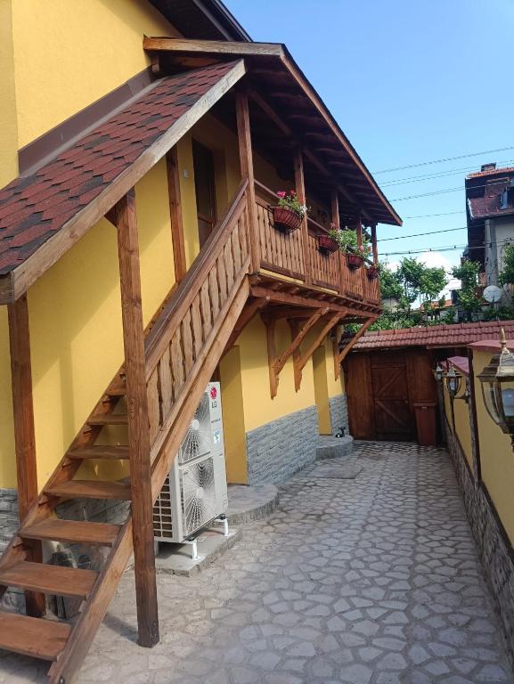 a house with a wooden balcony and a staircase at Guest house Dinaya-2 in Dobrinishte