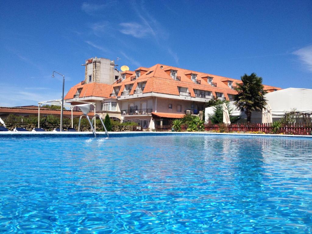 uma grande piscina em frente a um edifício em San Marcos Salnés em Cambados