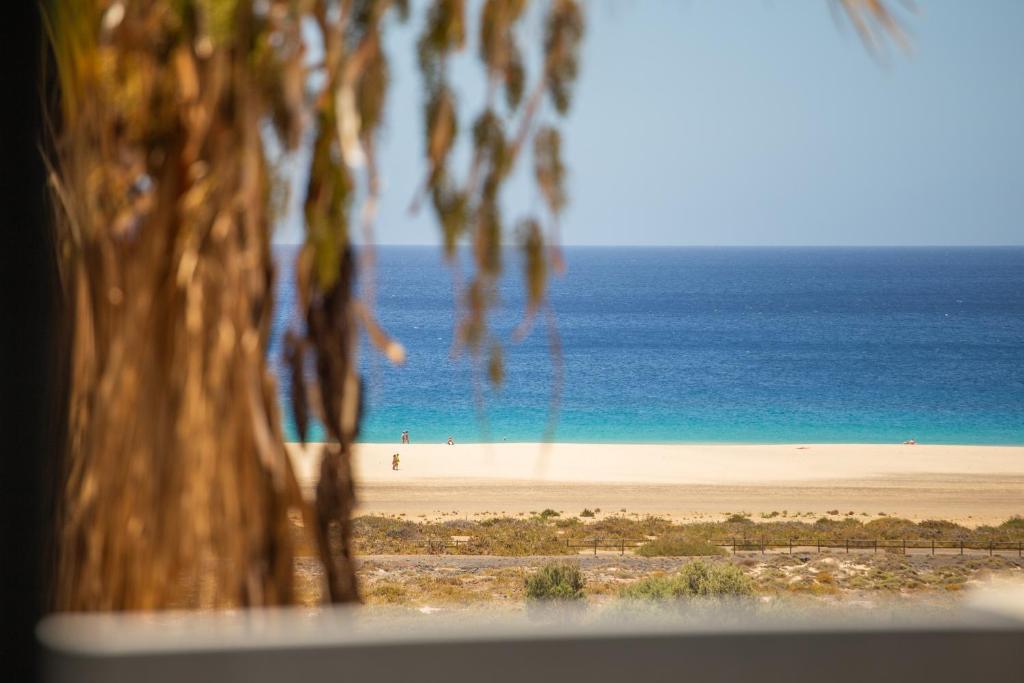 a view of a beach with people in the distance at Jandia Sunrise, Your Sweet Holiday Home in Morro del Jable