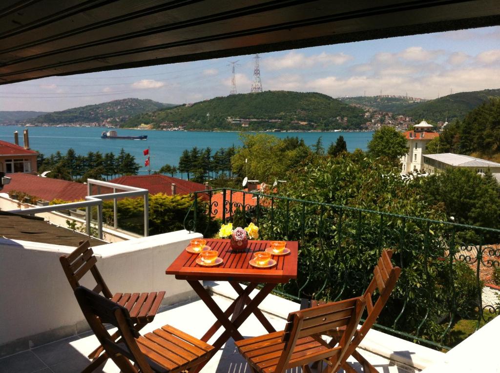 a table on a balcony with a view of the water at Villa Bosphorus Konak in Istanbul