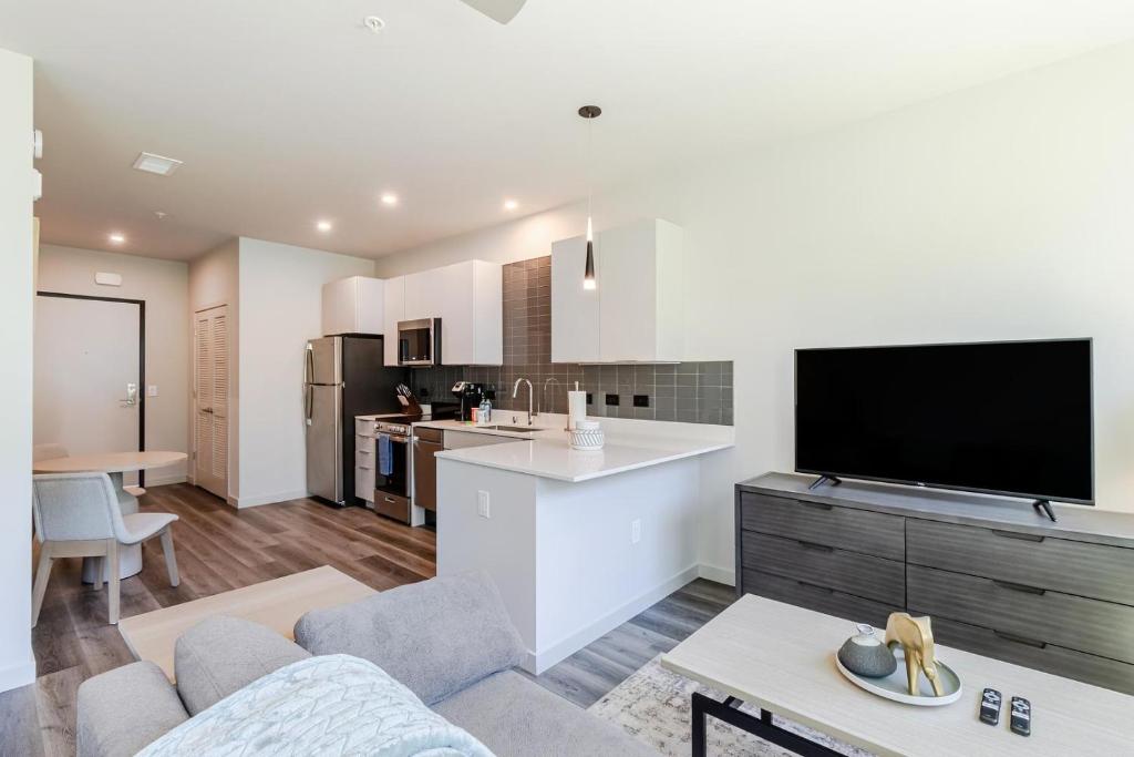 a kitchen and living room with a tv and a couch at Landing at Emory at RED - Reno in Reno