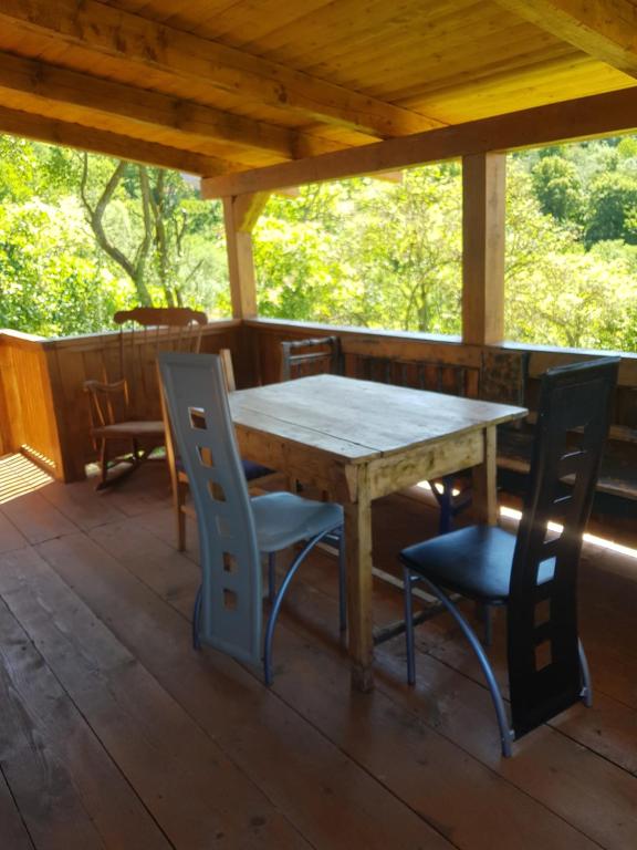 a wooden table and chairs on a porch at Casa La Casiru 6 in Straja