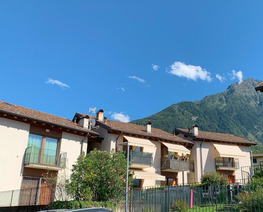 a row of apartment buildings with mountains in the background at Casa Vacanze La Madoneta in Colico