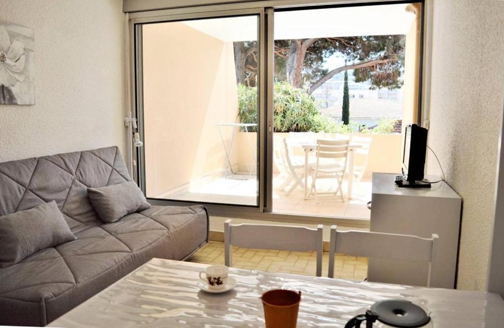 a living room with a couch and a table at Joli studio cabine à 500m plages in Cavalaire-sur-Mer