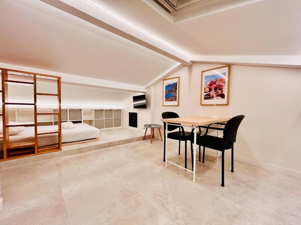 Un dormitorio con una cama y una mesa y sillas. en Attic Nest Intimité - confort en coliving, en Cagnes-sur-Mer