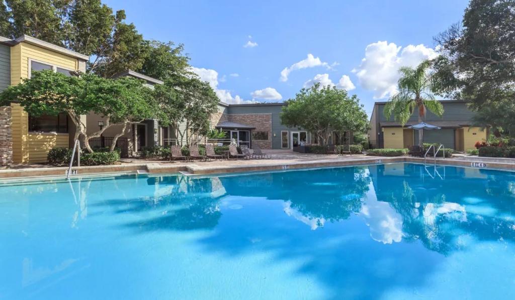 a large blue swimming pool in front of a house at Landing Fort Myers - Forestwood in Fort Myers