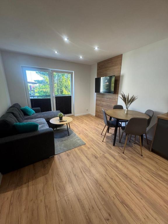 a living room with a couch and a table at Apartament Oli in Ostróda