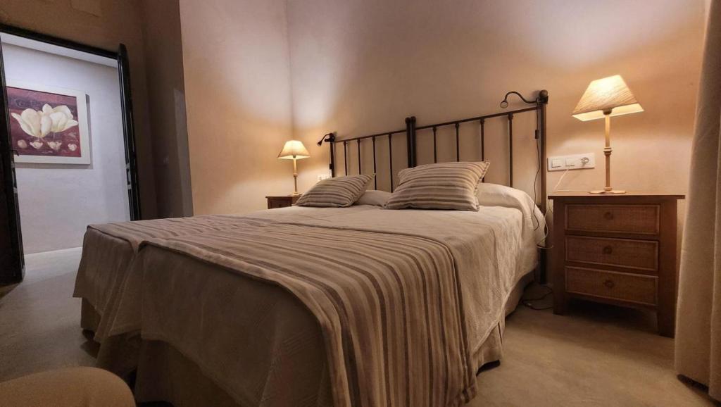 a bedroom with a large bed and two lamps on tables at El Garrotal de Medina in Carmona