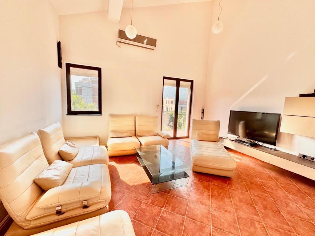 a living room with a couch and a tv at Kumbor sunny port with shared pool in Kumbor