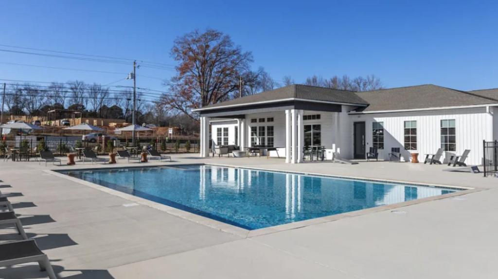a swimming pool in front of a house at Landing Furnished Apartments - Madison in Madison
