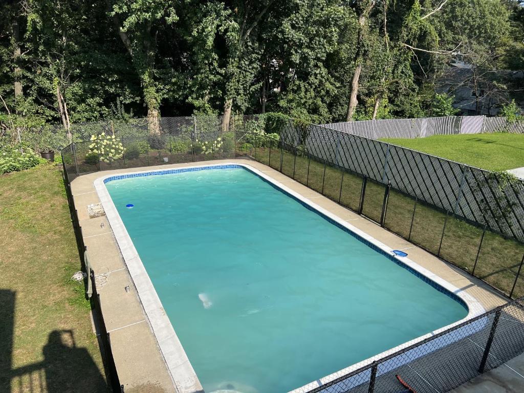 una piscina con una valla alrededor en Elegant New England Home with Private Pool, en Woburn