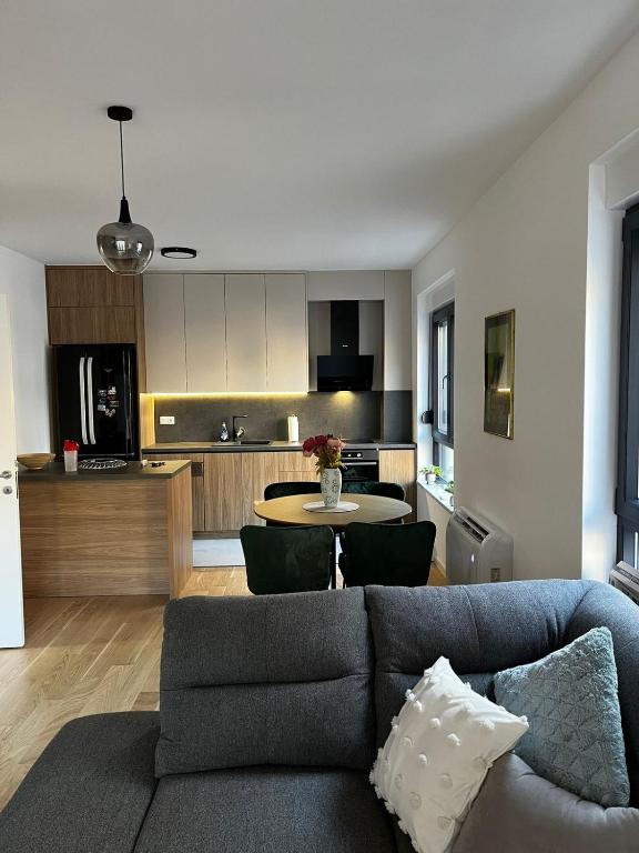 a living room with a couch and a kitchen at Apartman Andrea in Trebinje
