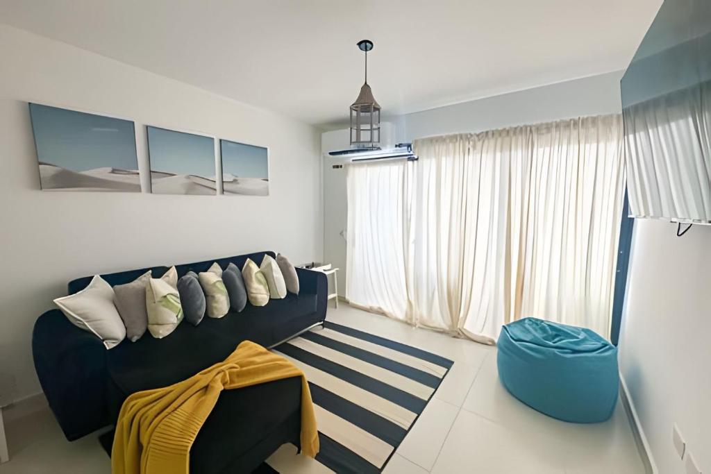 ein Wohnzimmer mit einem blauen Sofa und einem Fenster in der Unterkunft Epic Punta Cana in Punta Cana