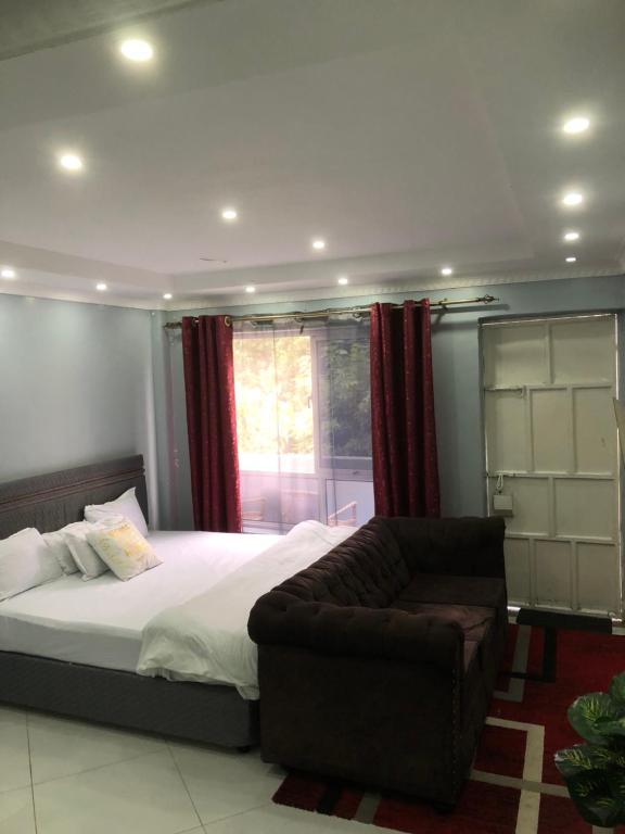 a bedroom with a bed and a couch at Bright Serene Studio Bnb in Nairobi