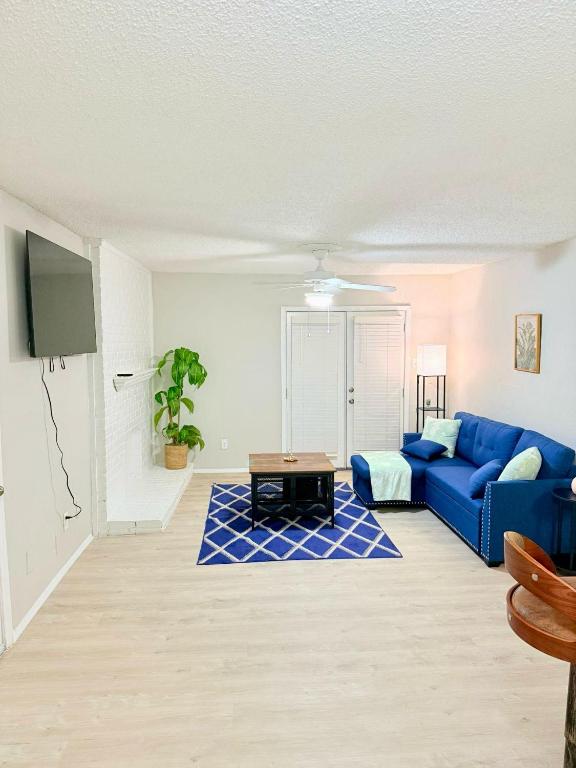 a living room with a blue couch and a table at Central 1BR Retreat by Hospital and tollway in Addison