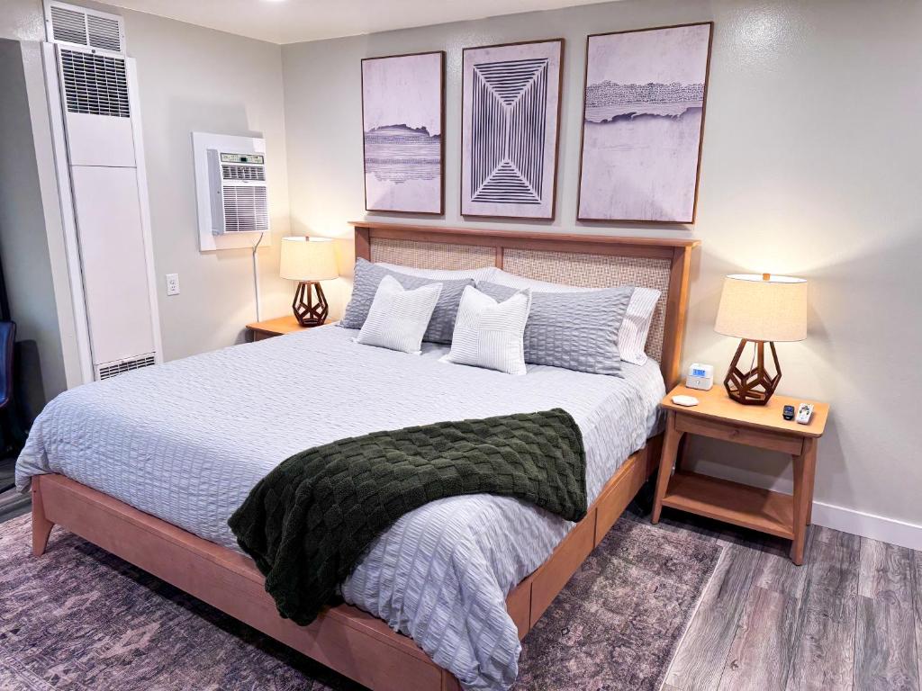 ein Schlafzimmer mit einem Bett mit zwei Lampen und zwei Tischen in der Unterkunft Modern Studio 65 TV, King Bed, Hot Tub in Park City