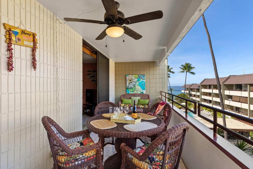 a balcony with a table and chairs and the ocean at Beachside Condo with Ocean Views in Kailua-Kona