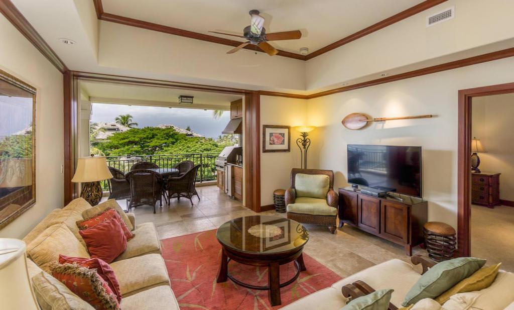 a living room with a couch and a tv at Kolea 14F - Heated Pool Gym & More in Waikoloa
