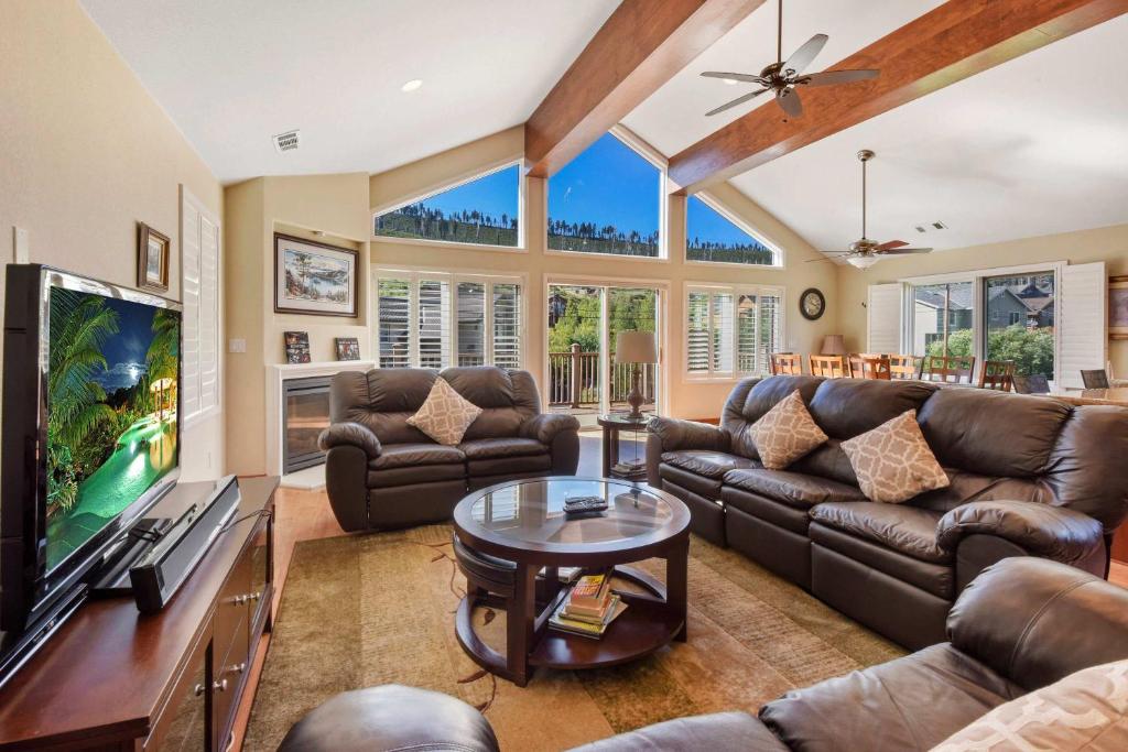 a living room with leather furniture and a flat screen tv at Mule Meadows - Classy Split level South Tahoe home in South Lake Tahoe