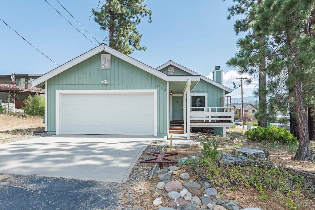 a green house with a white garage at Elk Forest Escape - Economy Family Abode in South Lake Tahoe