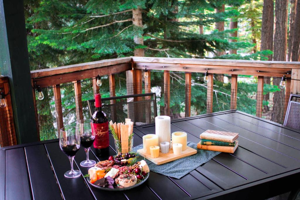 einen Tisch mit Speisen und Wein auf einer Terrasse in der Unterkunft Cherry Hills Cabin - Sleeps 6 No Pets Family Fun in South Lake Tahoe