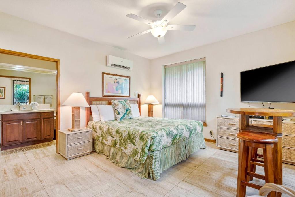 a bedroom with a bed and a flat screen tv at Romantic Studio in Waikoloa Beach Resort in Waikoloa