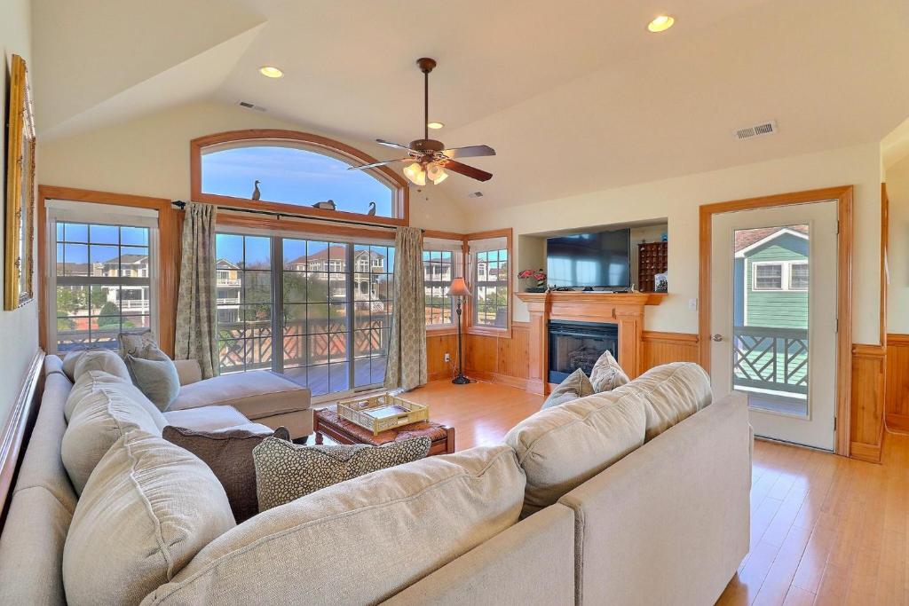 a living room with a large couch and a fireplace at 4124 - Sound Side Out in Kitty Hawk