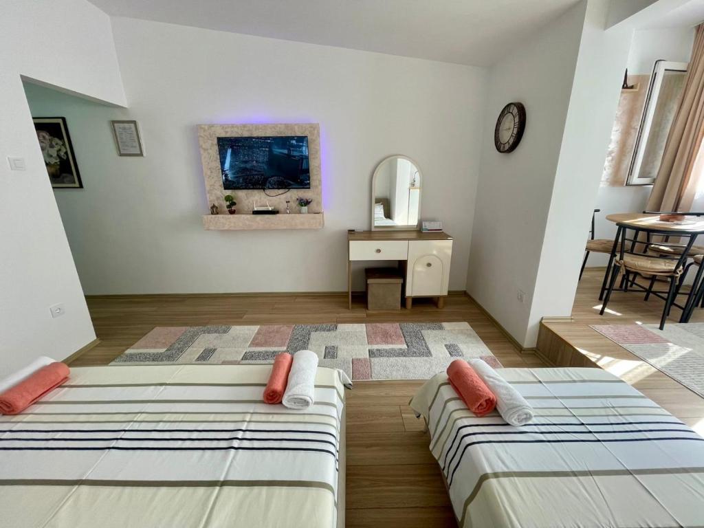 two beds in a room with a mirror and a table at Lina Apartment Prizren in Prizren