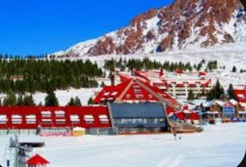 un lodge de esquí en la nieve frente a una montaña en Llancanelo, en Malargüe