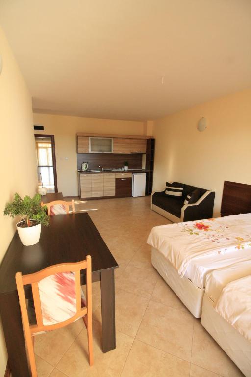 a bedroom with a bed and a table and a couch at Hotel Marant in Sozopol