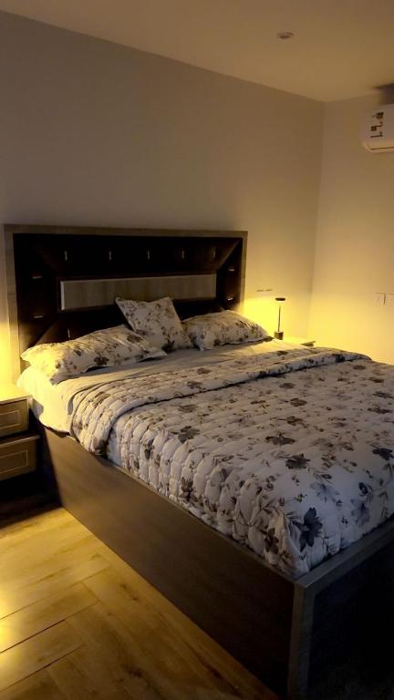 ターイフにあるجناح الراحه الفندقيの木製のヘッドボードが付いた大きなベッドのある寝室