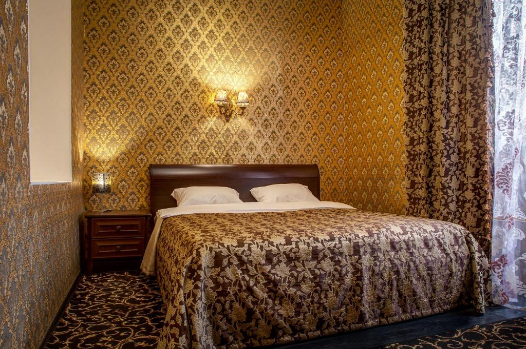 ヴォルゴグラードにあるフラント ホテルのベッドルーム1室(黄色の壁紙のベッド1台付)