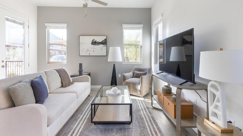 a living room with a white couch and a tv at Landing Apartments - Linda Vista in Oro Valley