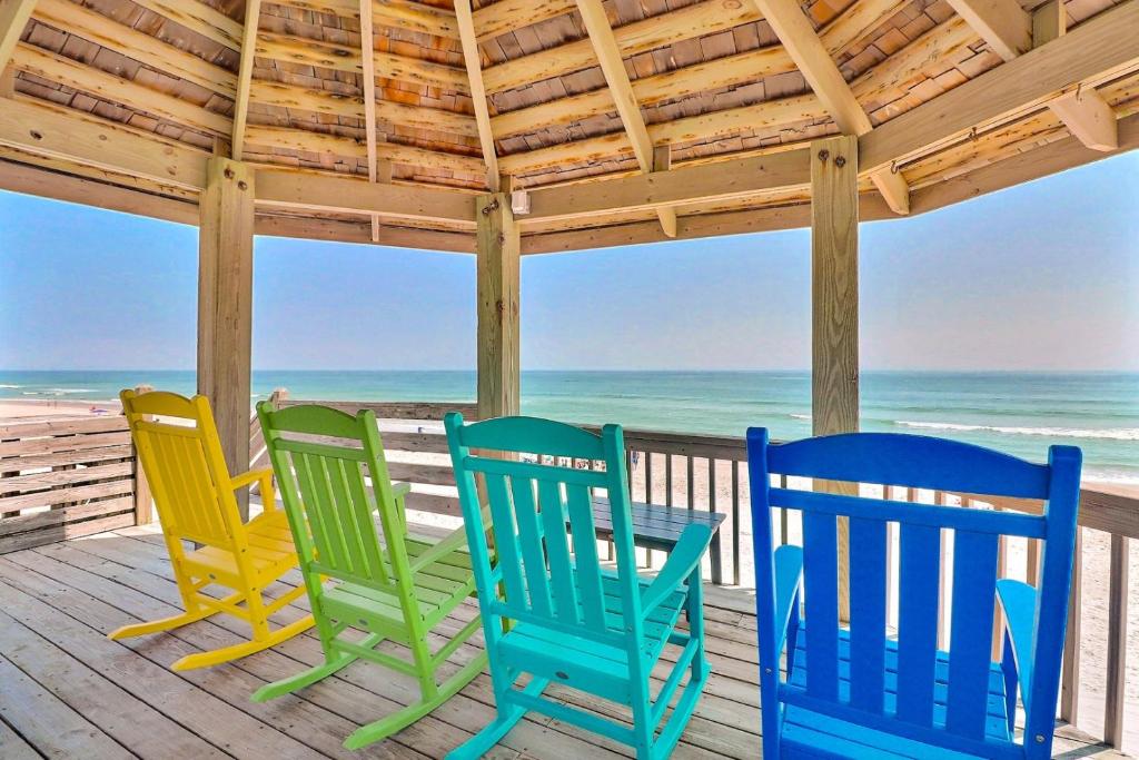 three chairs sitting on a porch overlooking the beach at 1245 - Castle Sween in Corolla