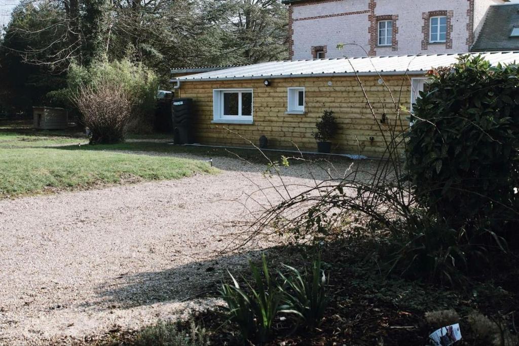 a house with a gravel driveway in front of it at Chambre indépendante avec salle de bain et toilettes in Romilly-sur-Andelle