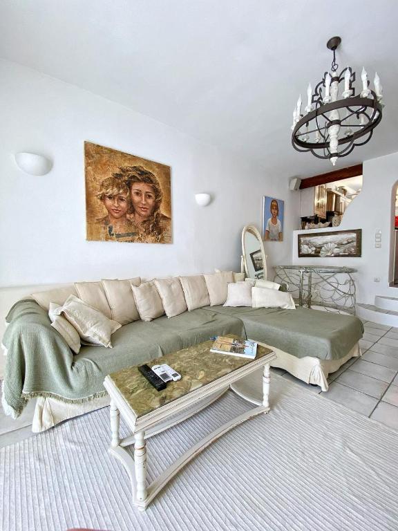 a living room with a couch and a table at Hébergement cycladique - près de Panormos in Mykonos