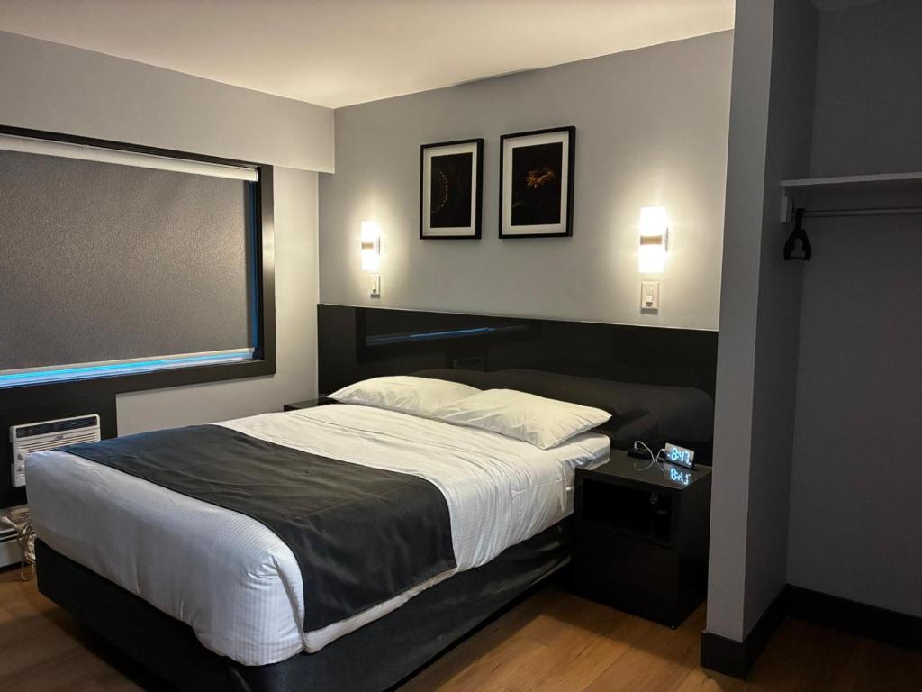 sypialnia z łóżkiem i dużym oknem w obiekcie Nights Inn w mieście One Hundred Mile House