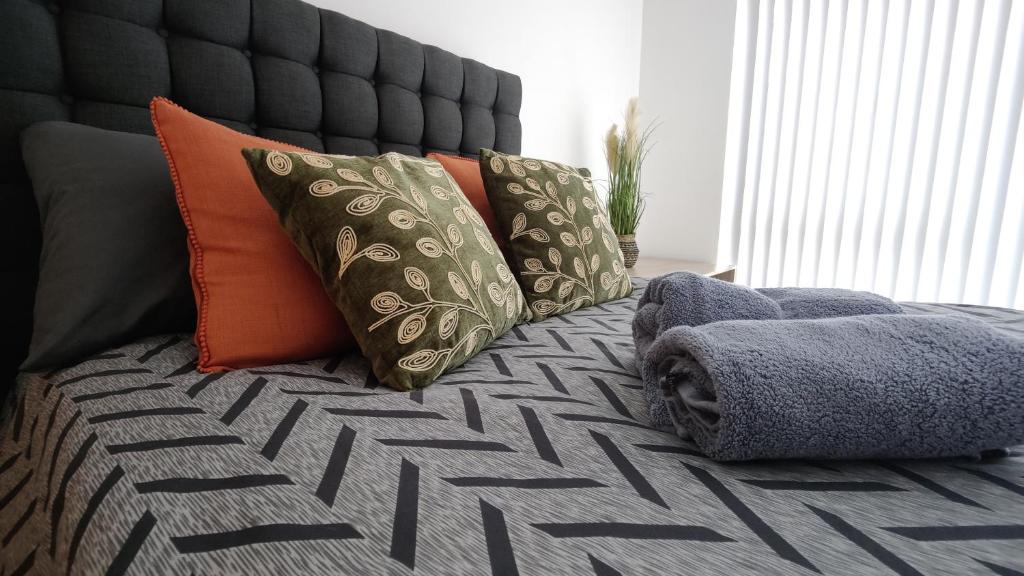 Hotel Bee City Cosy Stay - Near Train Stations and Shopping Centre with Paid Private Parking, 500Mbps Internet and Netflix, a bed with a bunch of pillows on it at Bee City Cosy Stay - Near Train Stations and Shopping Centre with Paid Private Parking, 500Mbps Internet and Netflix in Manchester