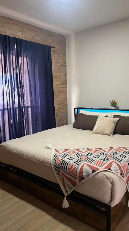 a large bed in a bedroom with a window at El Rincón de Monte Alban in Oaxaca City