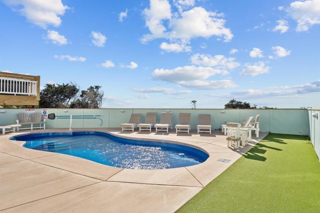 a patio with chairs and a pool on a building at 8478 - Seas the Breeze II in Avon