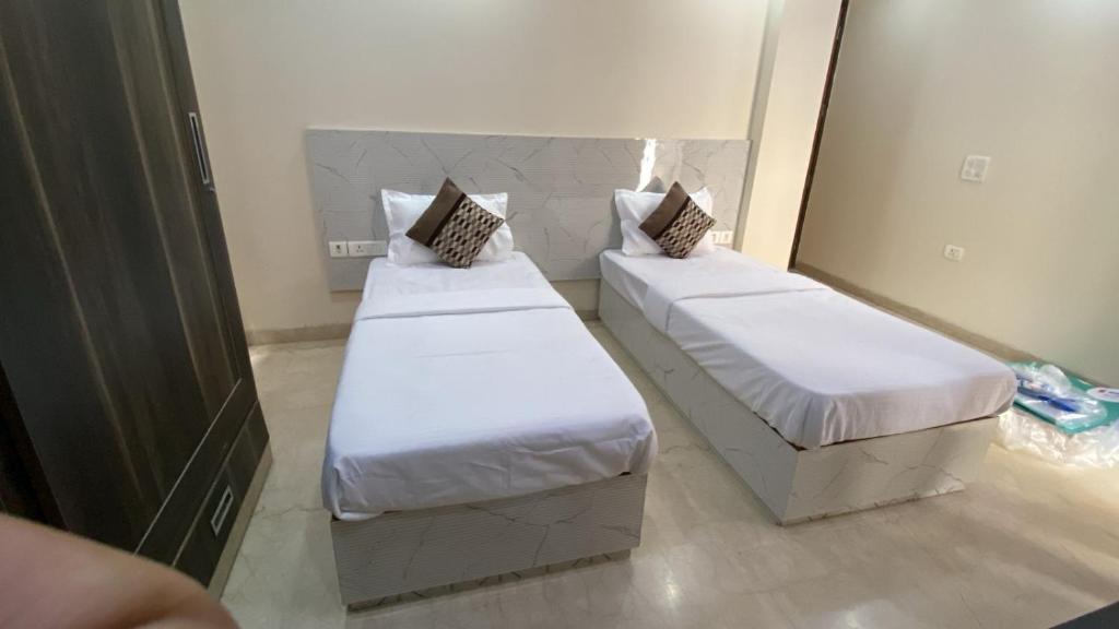 a room with two beds and a mirror at Cassava Stay in New Delhi