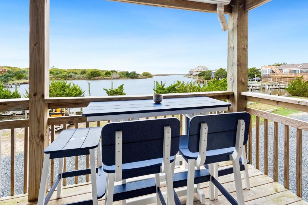 a table and chairs on a deck with a view of the water at PC3 - Pelican's Hideaway in Avon