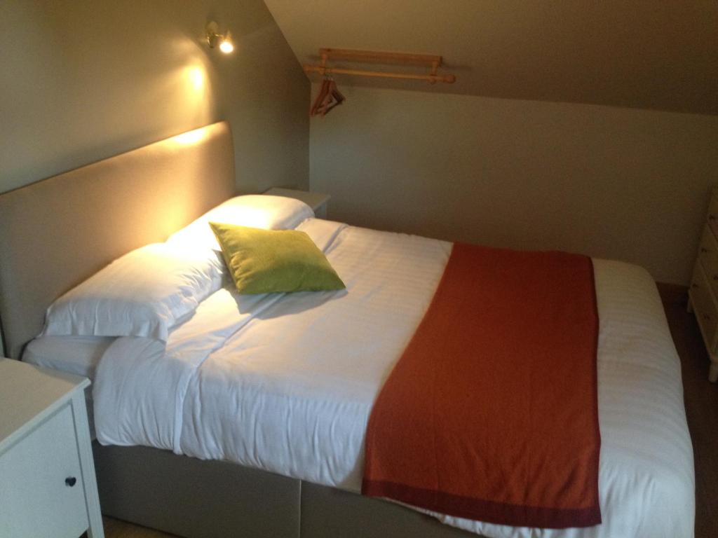 a bedroom with a white bed with a yellow pillow at Carragh House in Castlebar