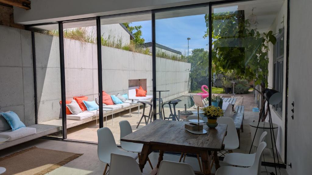 a patio with a wooden table and white chairs at endless summer lodge in Frauenkirchen