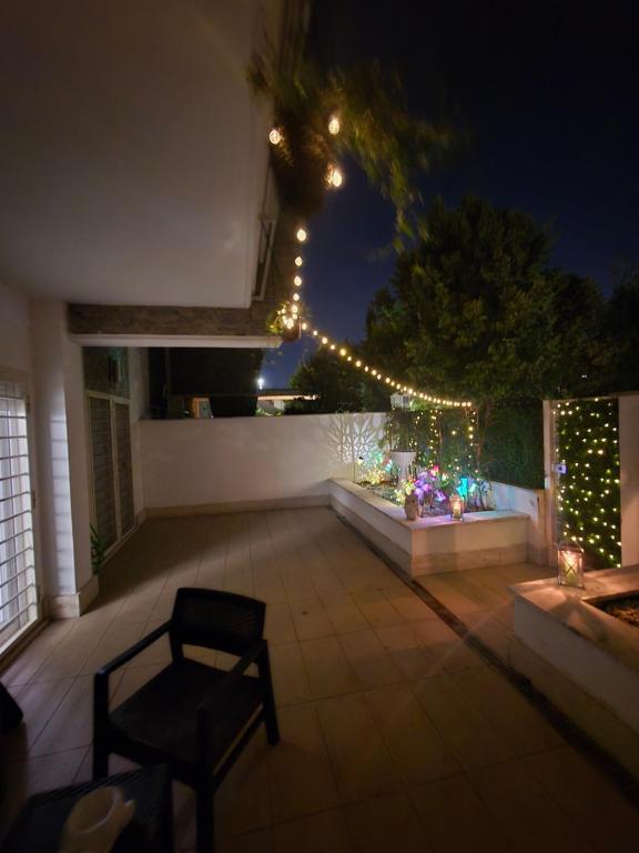 Un patio de noche con luces y una silla. en Welcome Love, en Acilia