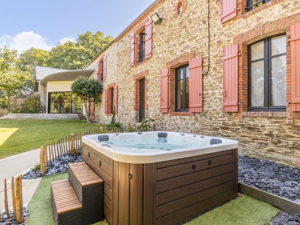 a hot tub in the yard of a house at Grande maison de campagne rénovée avec parking et espace détente - FR-1-306-1303 in Malville