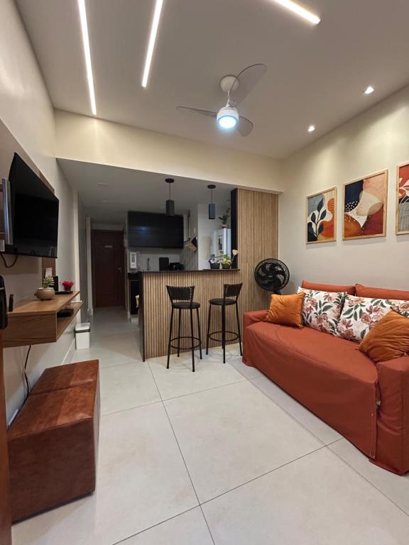 Hotel Solar de Copacabana-Vista Frente, a living room with a red couch and a kitchen at Solar de Copacabana-Vista Frente in Rio de Janeiro