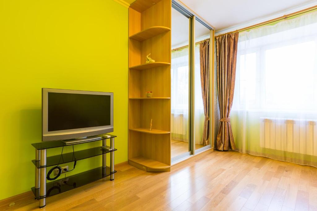 a living room with a television and a green wall at Star Apartment On Kyievskaya in Moscow